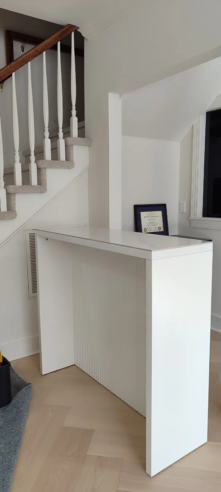 Assembled white bar counter beside the stairs