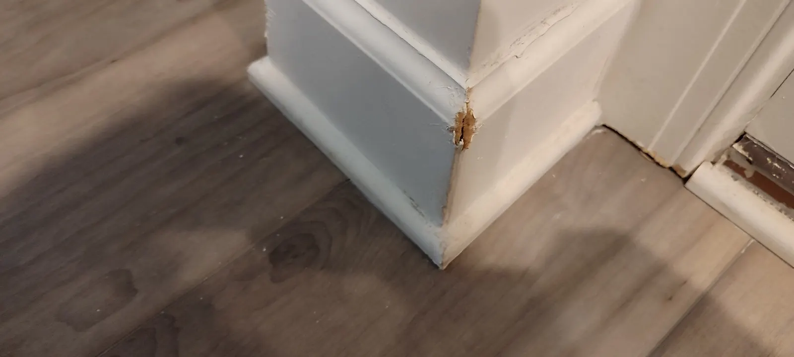 Damaged baseboard corner beside a doorway