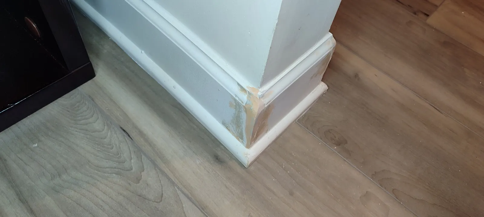 Repaired baseboard corner beside the cabinet