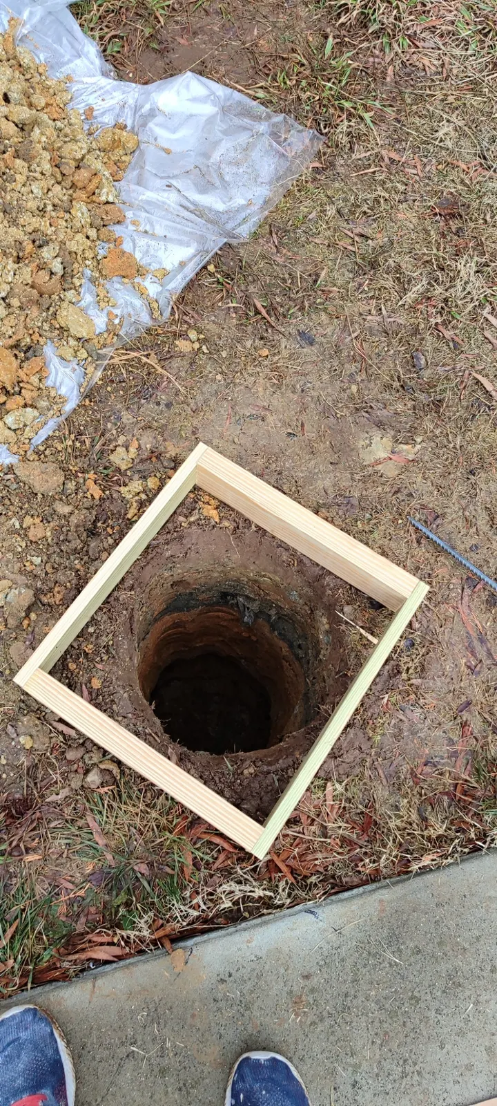 Excavated hole and wooden form for the basketball hoop footing