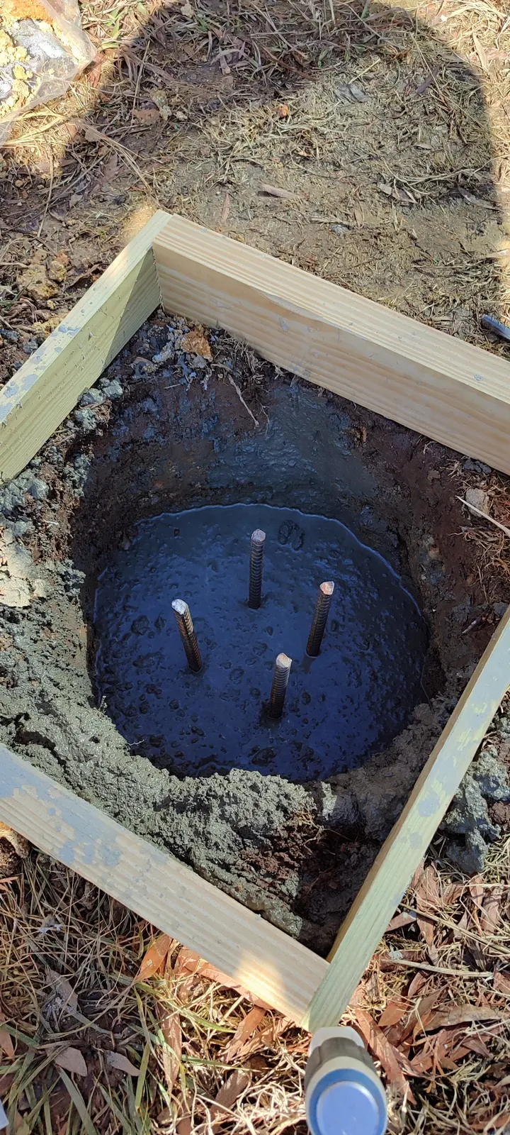 Anchor rods set in the concrete footing during the pour