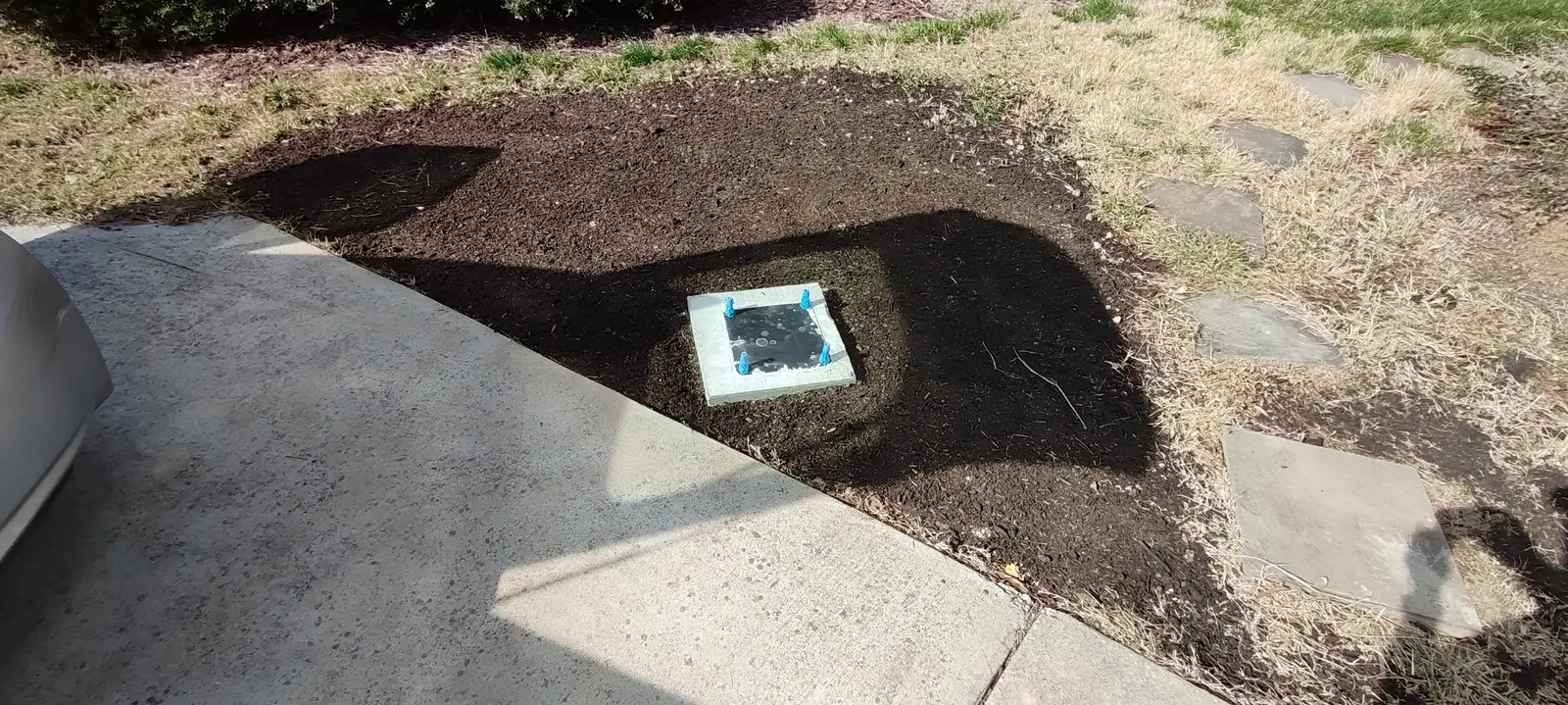 Concrete footing beside the driveway with the surrounding soil leveled