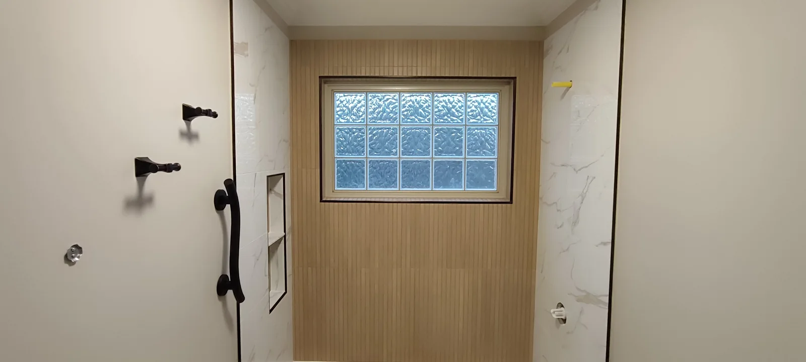 Wide view of the tiled bath surround before the final shower fittings were installed.