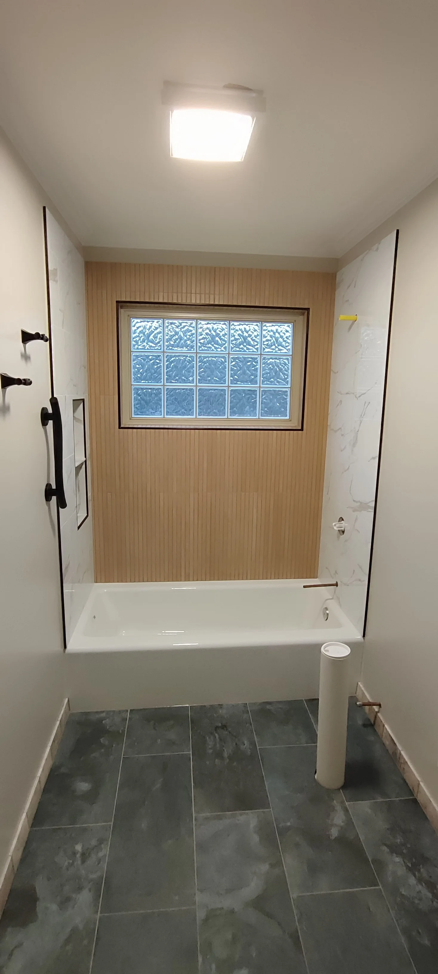 Bathroom floor and wall tiles before the vanity, toilet and final shower fittings were in place.