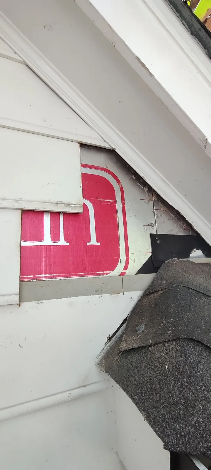 Roof-to-wall area exposed after removing the damaged siding pieces