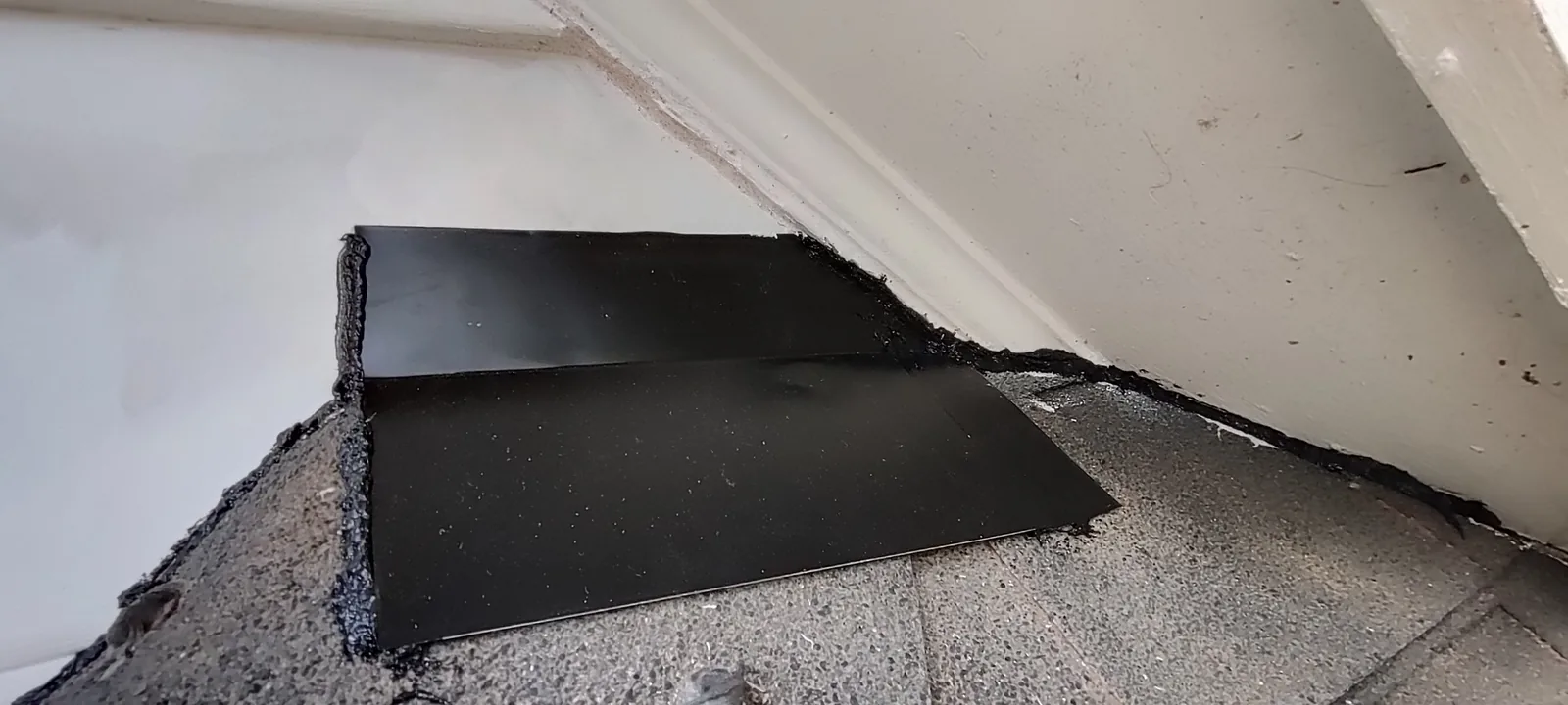 New metal flashing installed at the roof-to-wall transition during the siding repair