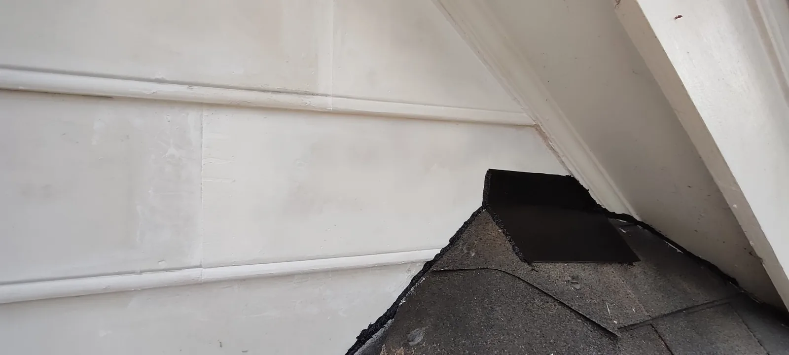 Roof-to-wall flashing fitted beneath the repaired siding area