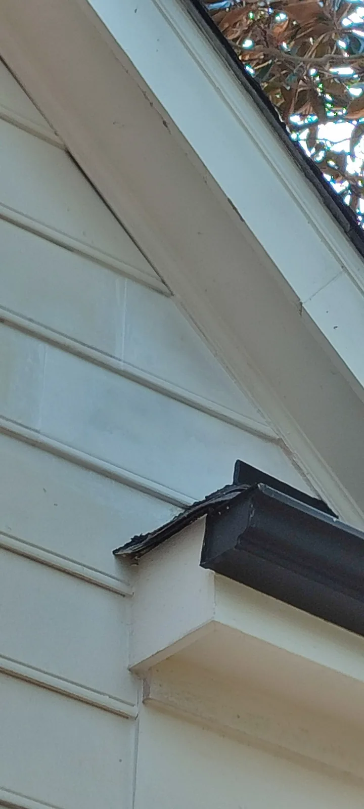 Finished roof-to-wall junction with repaired siding and new flashing
