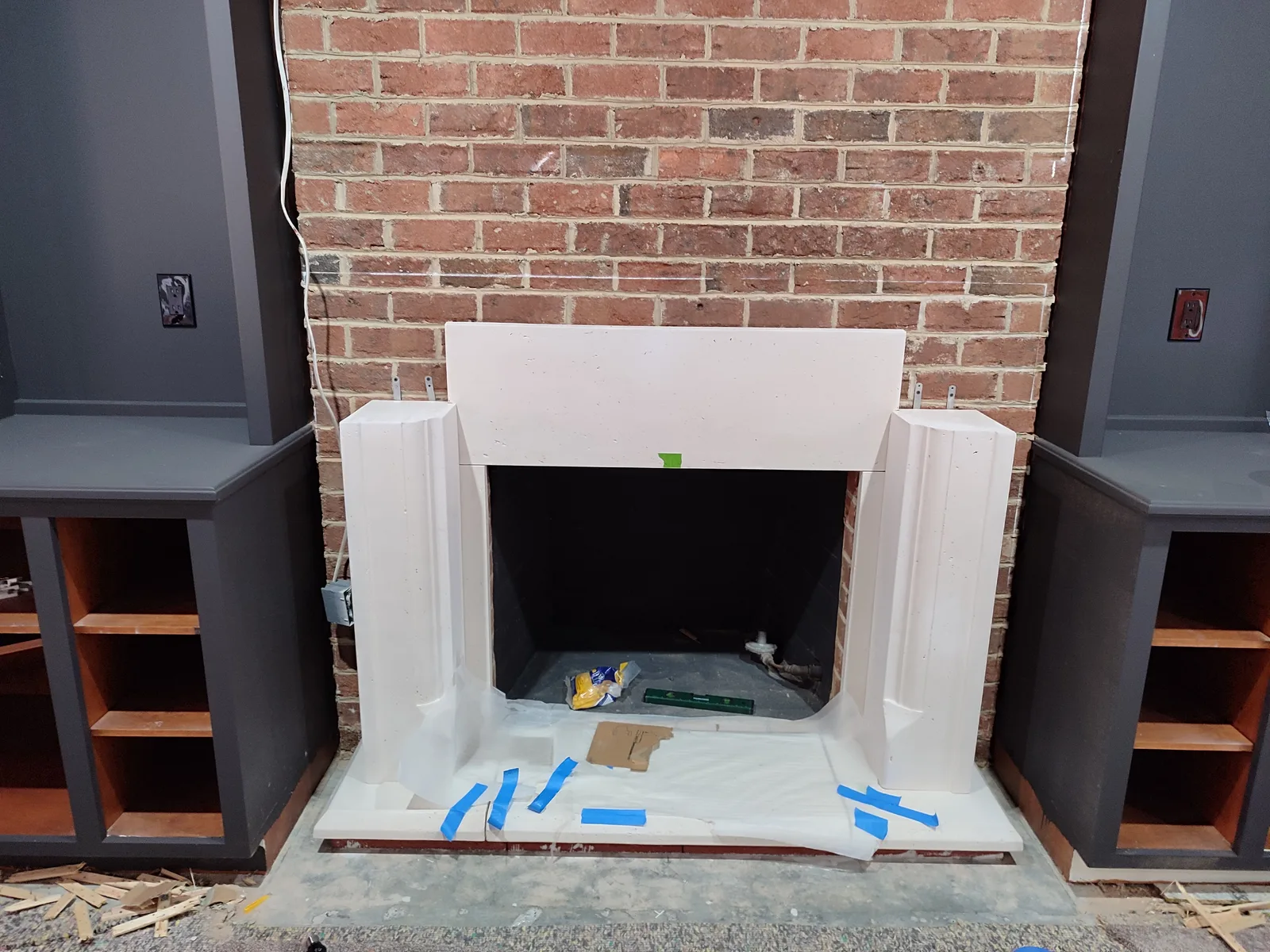 Fireplace during fitting and installation of decorative mantel trim.
