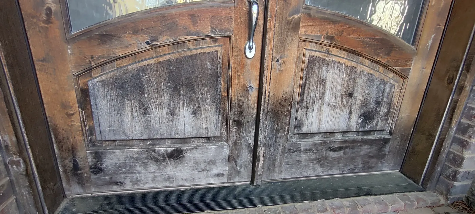 Worn finish across the lower entry-door panels