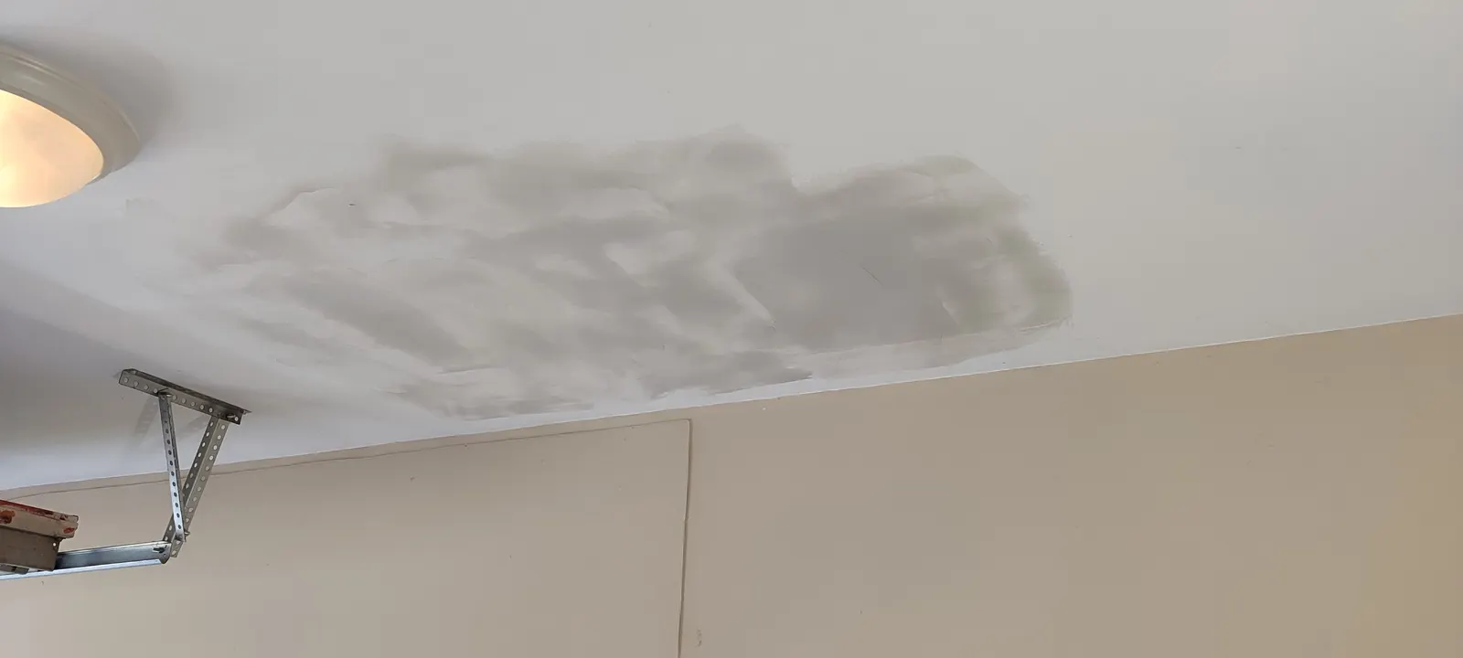 Patched garage ceiling during surface finishing