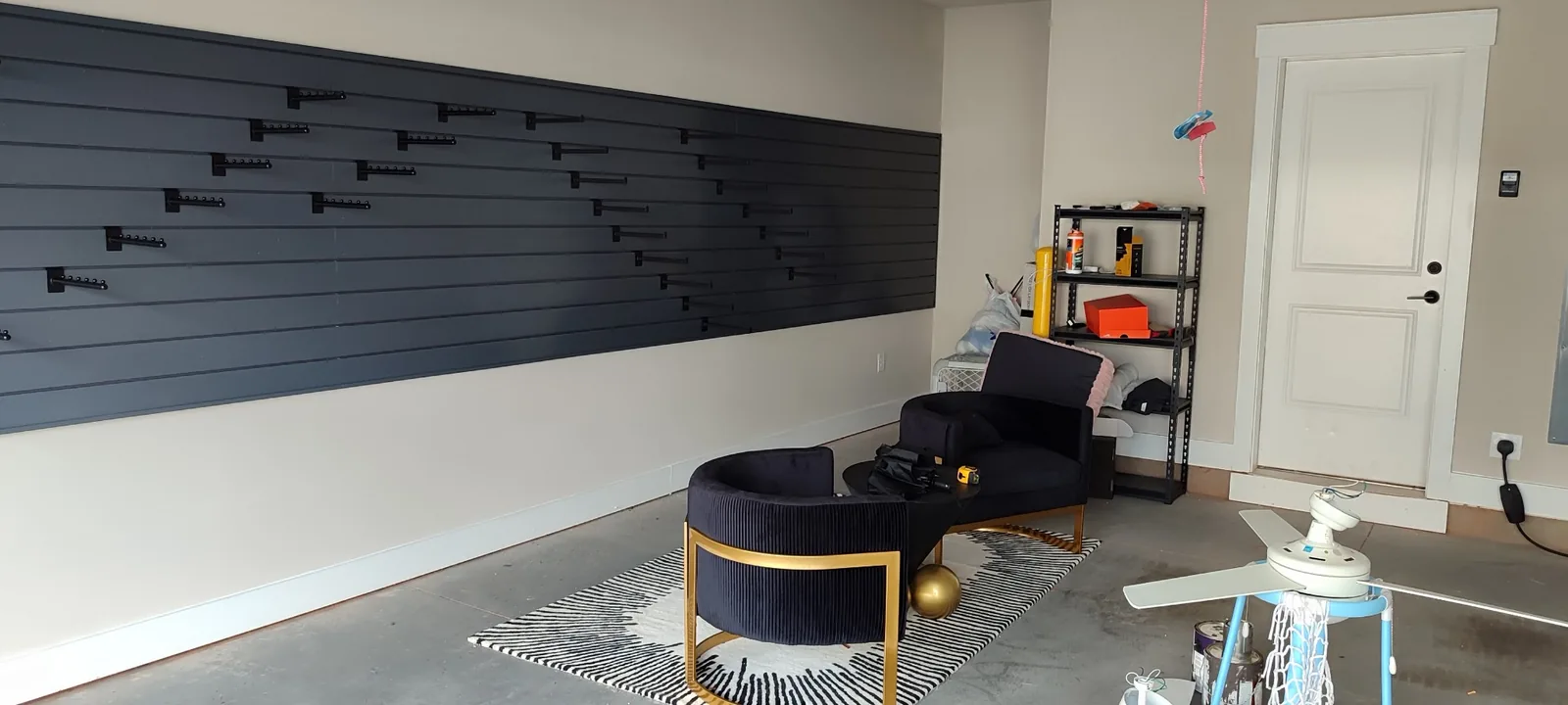 Completed garage PVC slatwall storage wall with multiple adjustable hooks installed