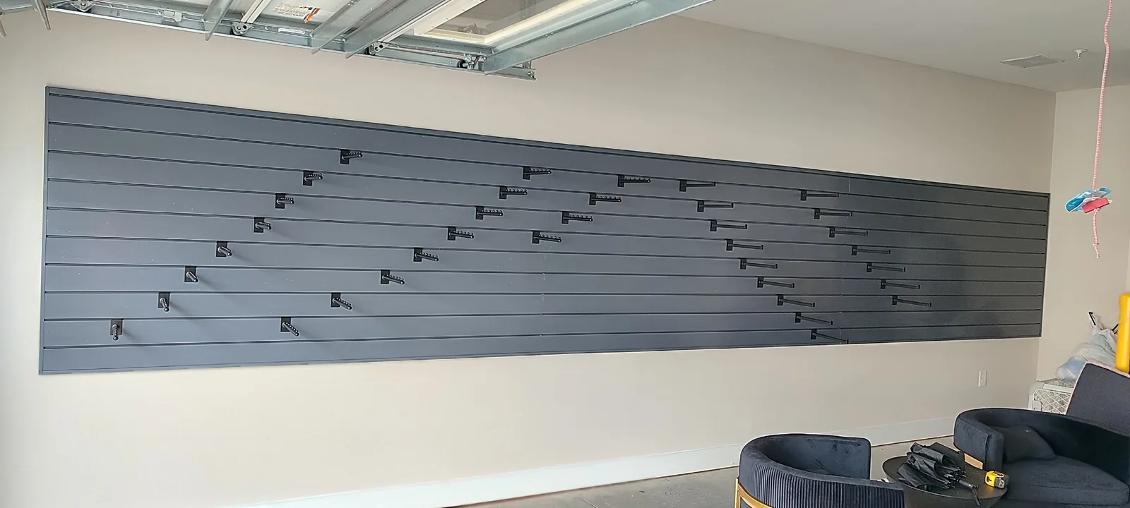 Wide view of the completed garage slatwall panel system with storage hooks