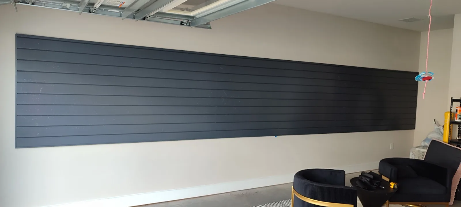 Large garage wall covered with aligned PVC slatwall panels in a continuous layout