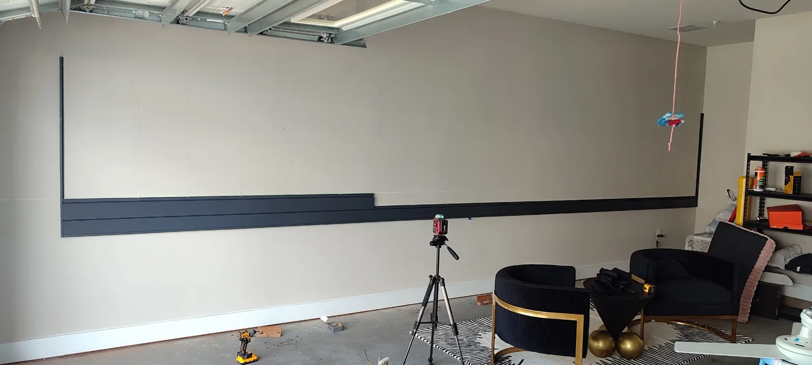 Garage slatwall panel installation in progress with lower rows aligned across the wall