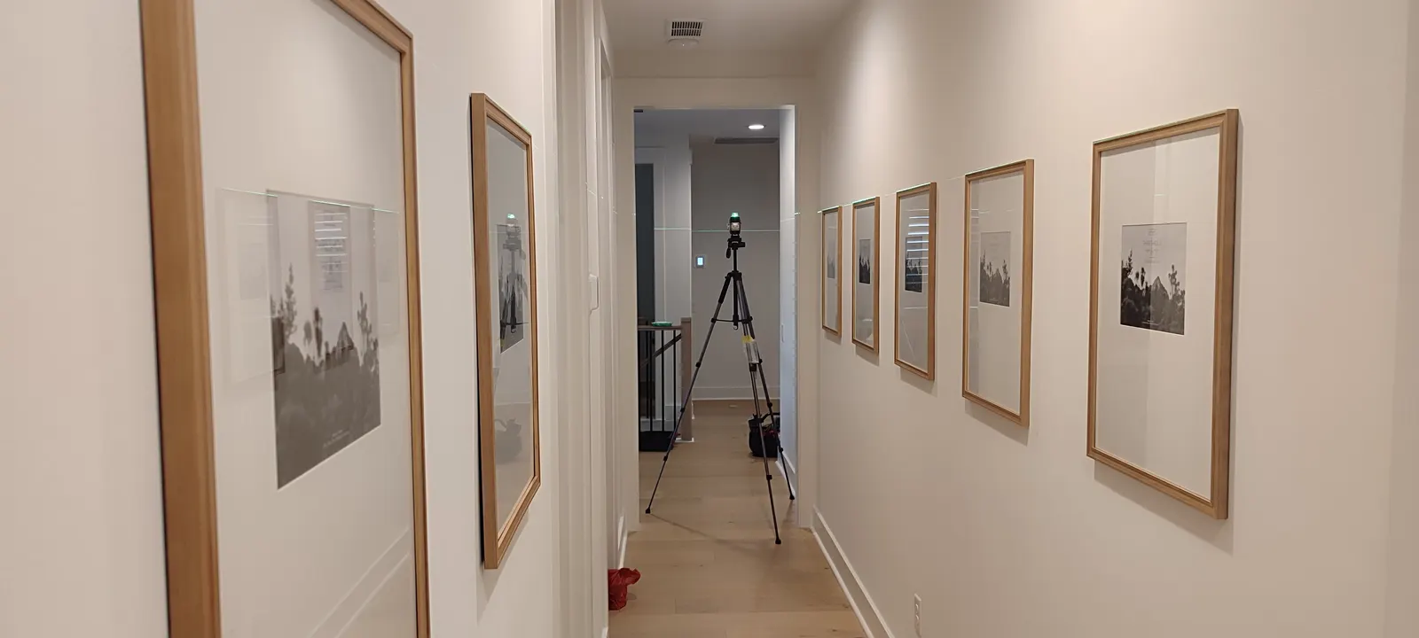 Wide view of framed pictures along both hallway walls