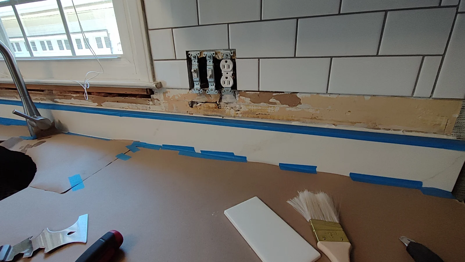 Protected countertop below the open backsplash section beside the sink