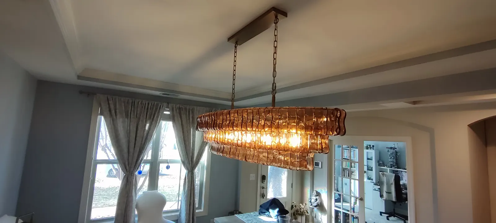 Wide room view of the installed chandelier