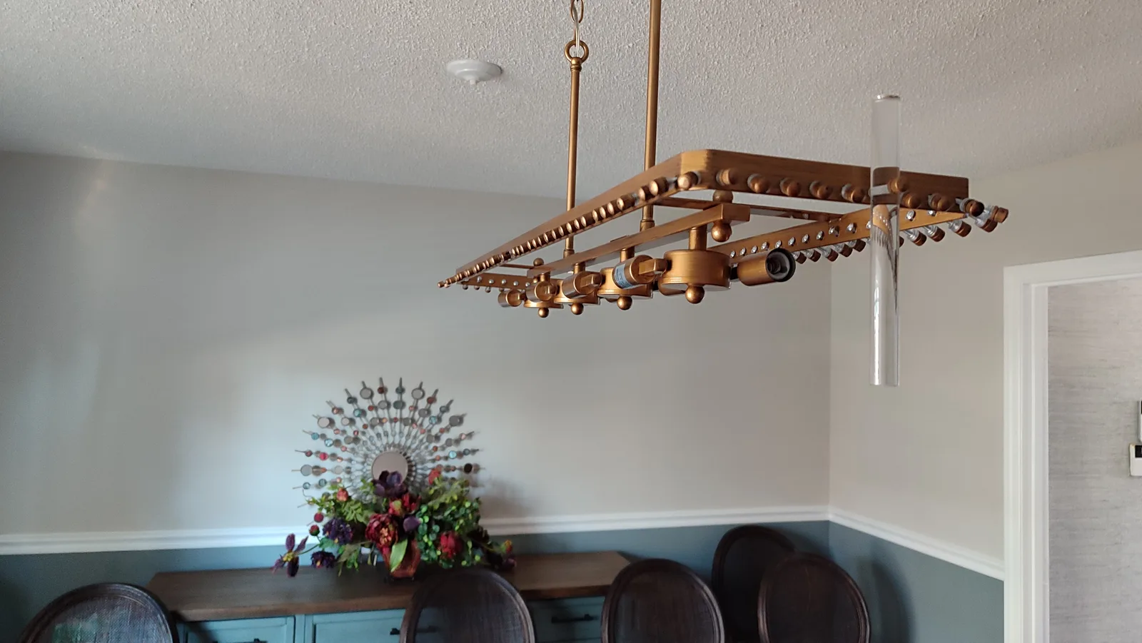 Installed linear pendant light above a dining area.