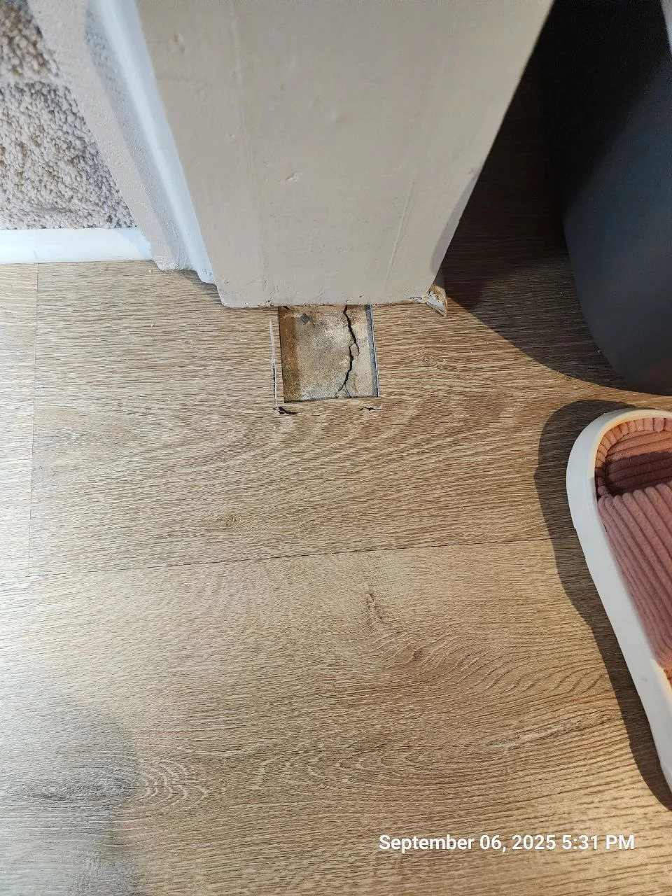 Exposed cutout in the LVP flooring beside the door casing