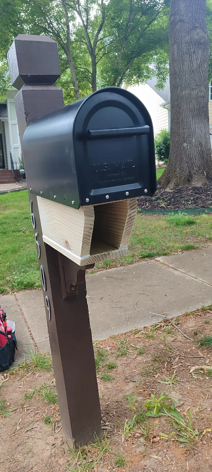 Front view of the mailbox and repaired wooden section