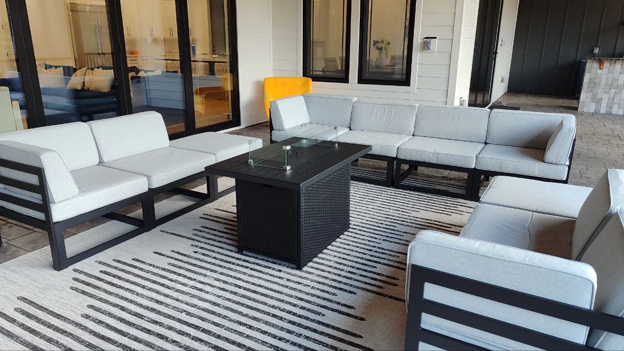 Outdoor seating arranged around a central table on a screened porch