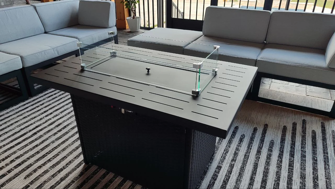 Central outdoor table with a glass wind guard and surrounding seating