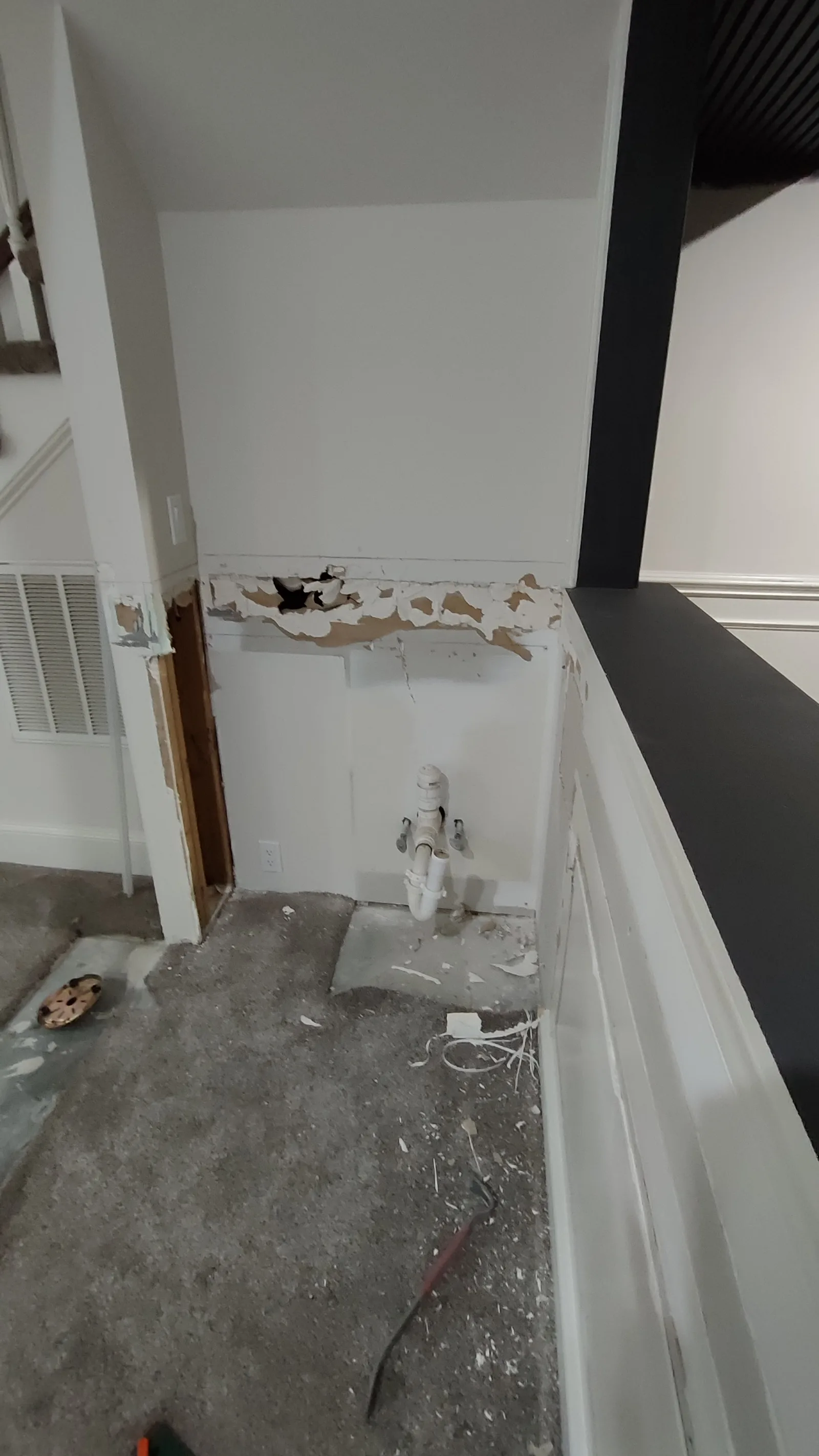 Damaged wall in a small kitchen before drywall repair.