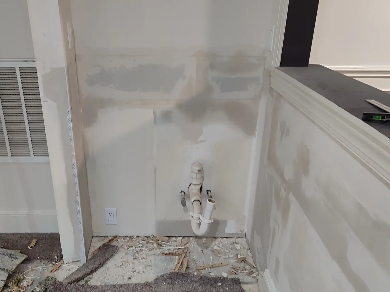 Restored drywall in a small kitchen after finishing and wall preparation.
