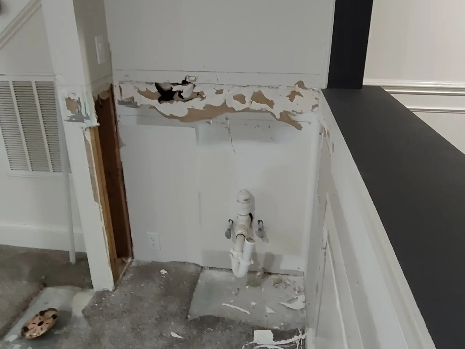 Damaged drywall in a small kitchen before repair.