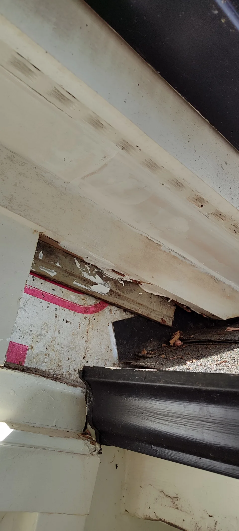 Open soffit section at the roof edge during repair.