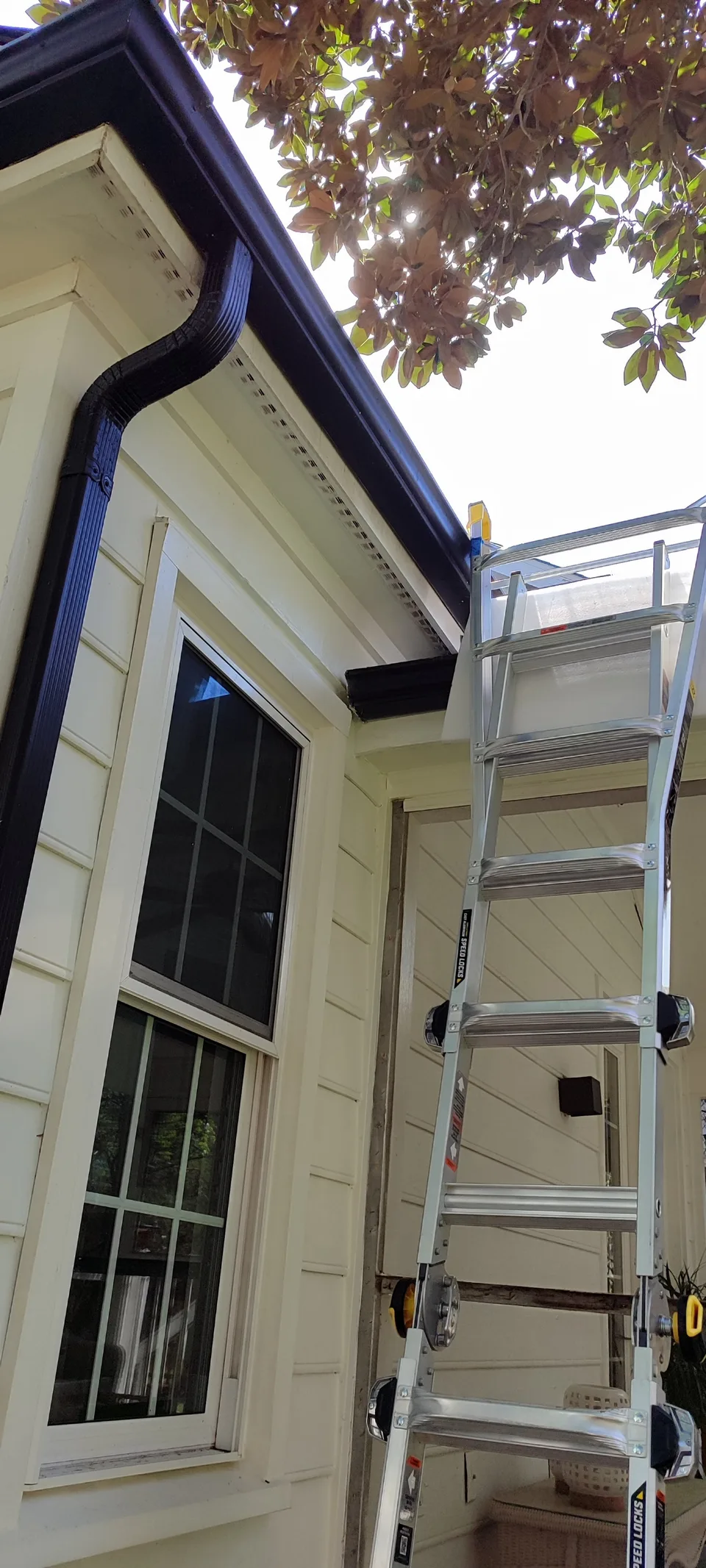 Full view of the repaired roof corner near the ladder.