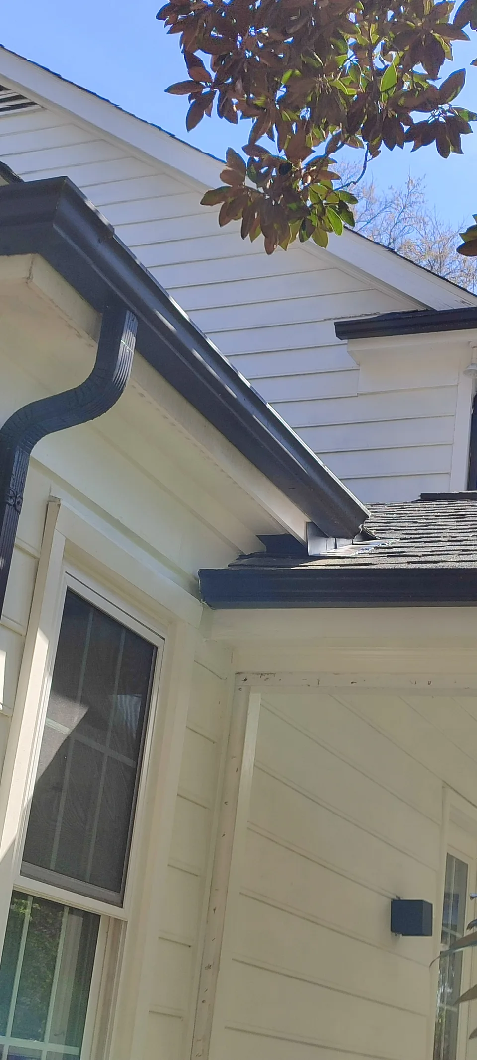 Repaired roof corner with restored white exterior trim.