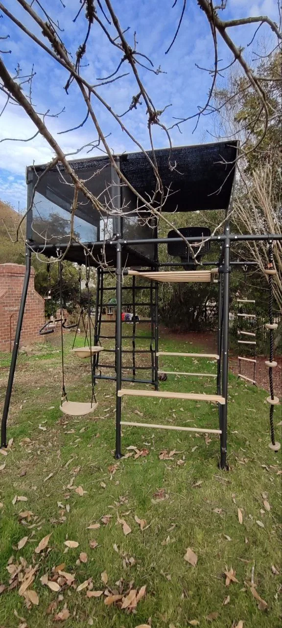 Vuly Quest playset showing climbing bars, swings, and the elevated play area