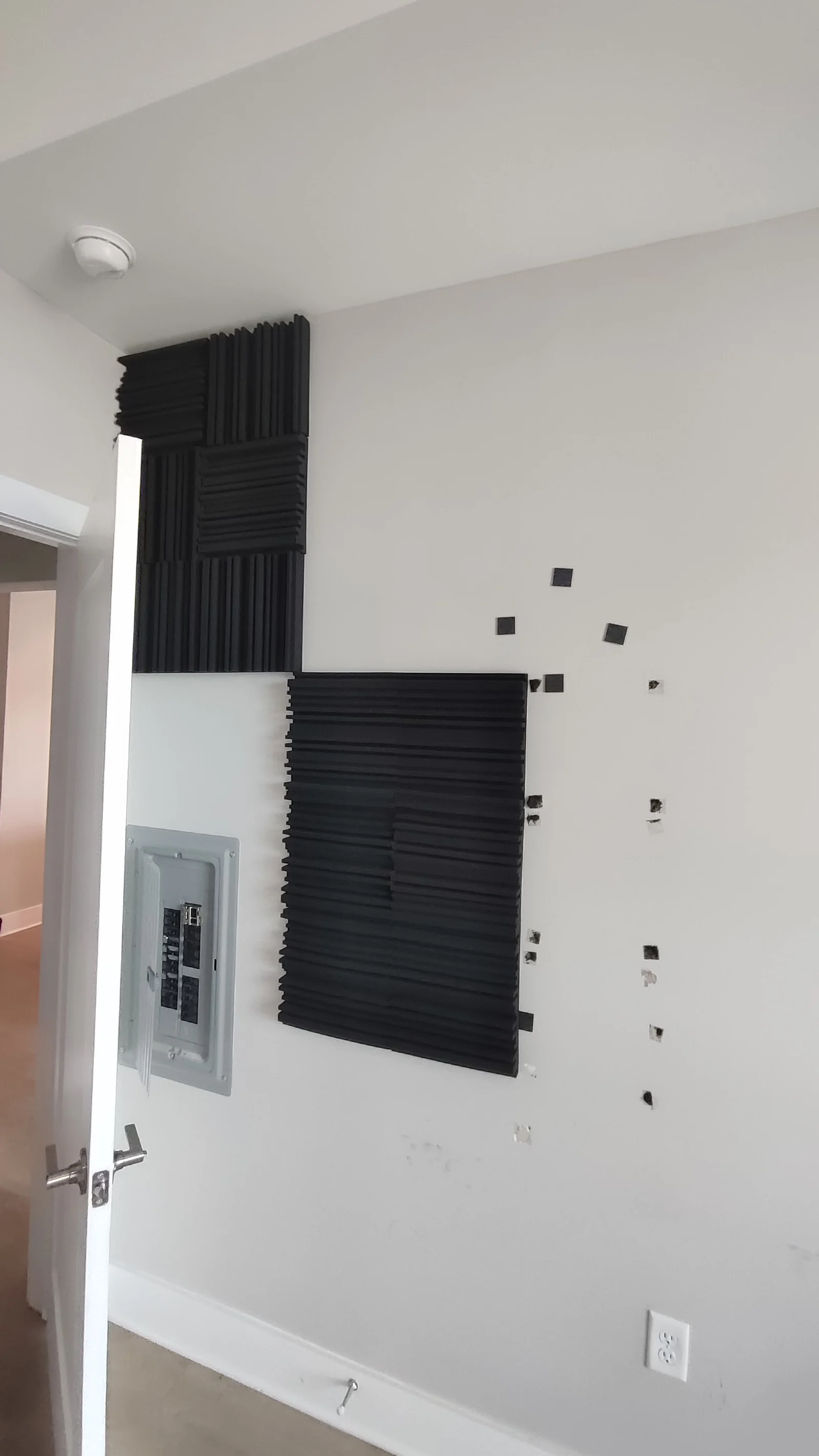 Acoustic panels on the wall above and beside the electrical panel