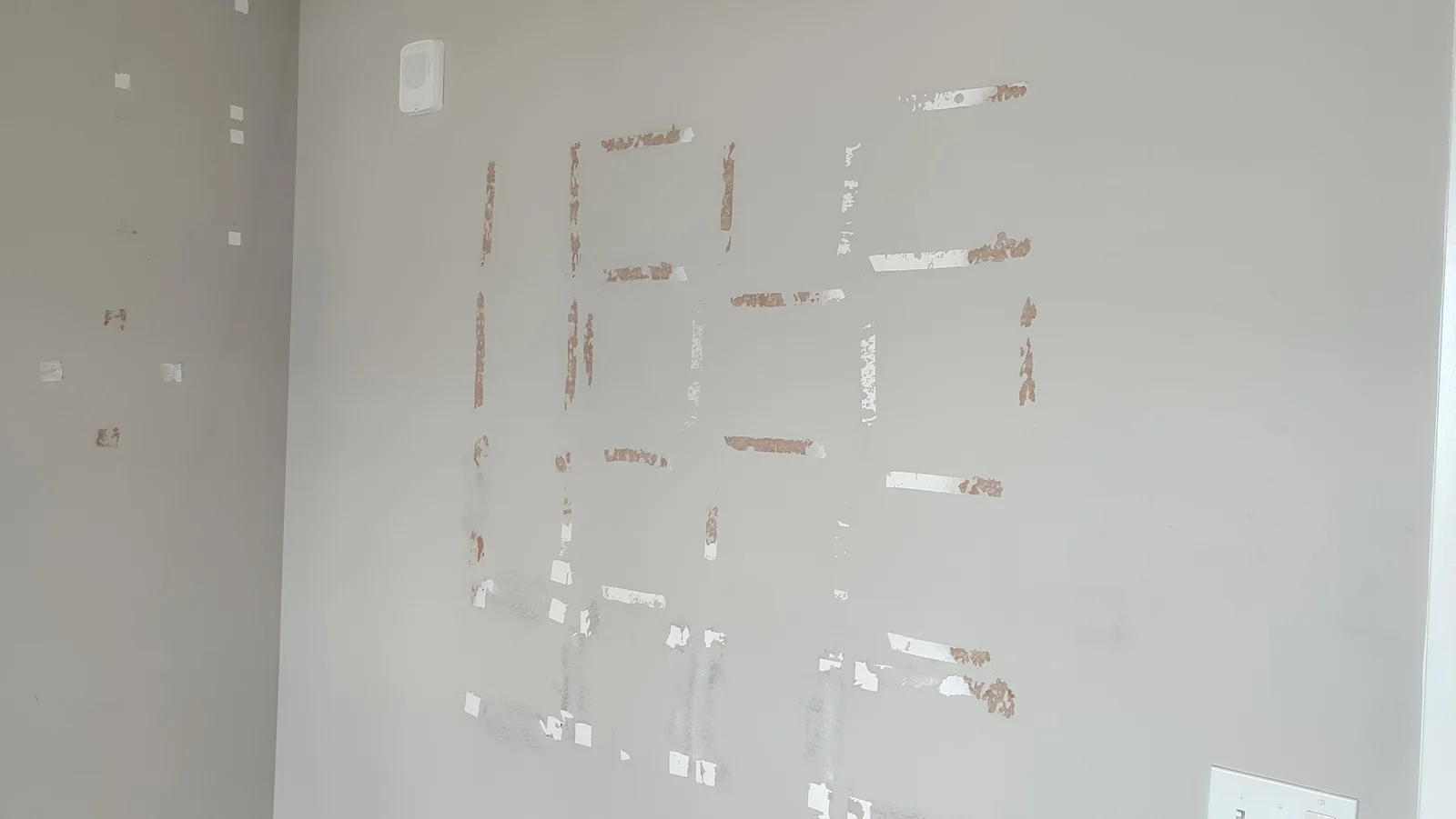 Torn wall surface where adhesive strips were removed