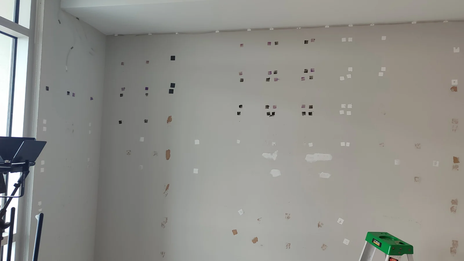 Main wall with adhesive marks and initial patching after panel removal