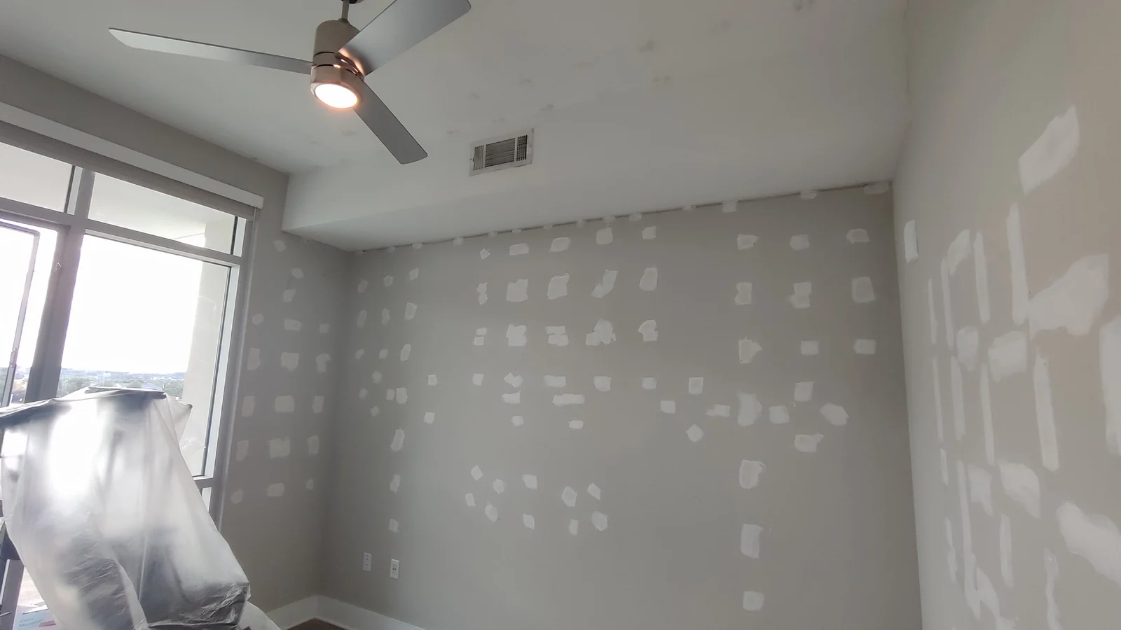 Room view of patched walls with the window on the left